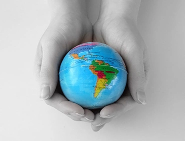 Zwei Hände halten einen Globus – Symbolbild für das internationale Kundenspektrum von PROJECTOR Germany